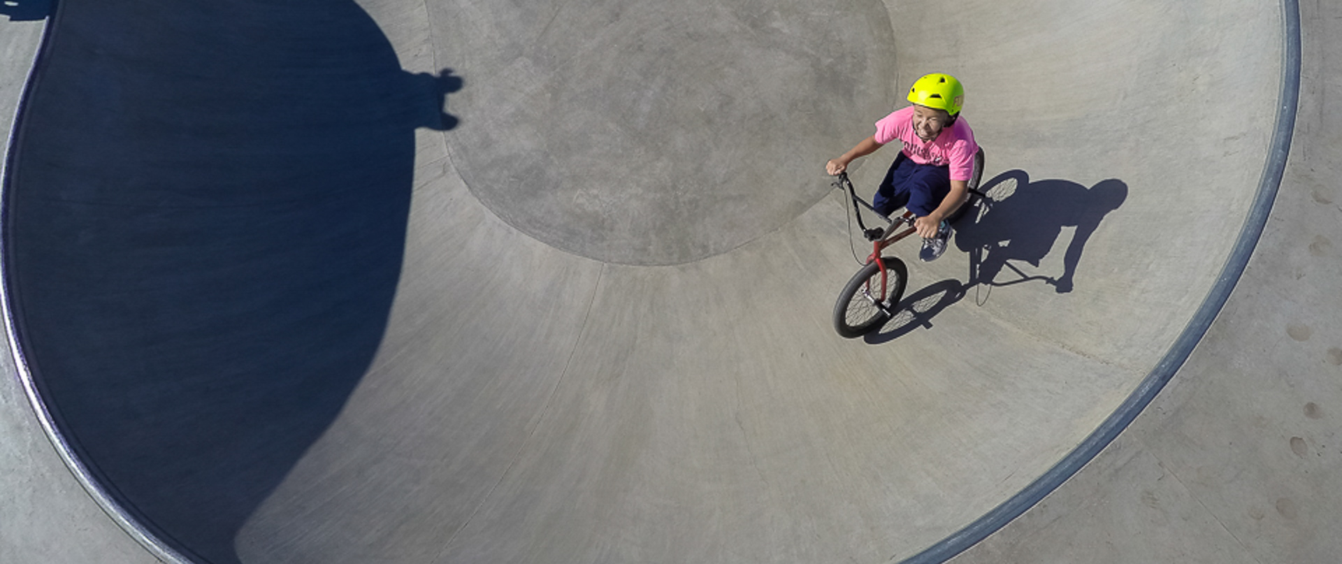 A girl smiling while biking in a skate park